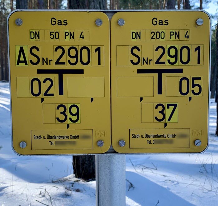 zwei kleine gelbe Schilder mit Angaben zu Gasarmaturen